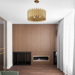 The contemporary living room features a stylish chandelier and an elegant wallmounted fireplace for comfort