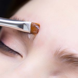 long-term eyebrow styling with the help of laminating formulations, the master applies the composition to the eyebrows with a brush