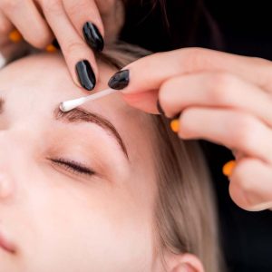 Pretty girl getting brow depilation at beauty salon