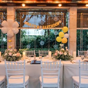 Setting up a banquet dining table with silverwave, wine glass for a birthday celebration, decor with bouquet, balloon in restaurant